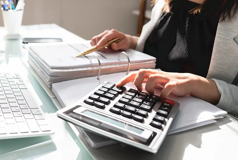 Person using calculator at a desk.