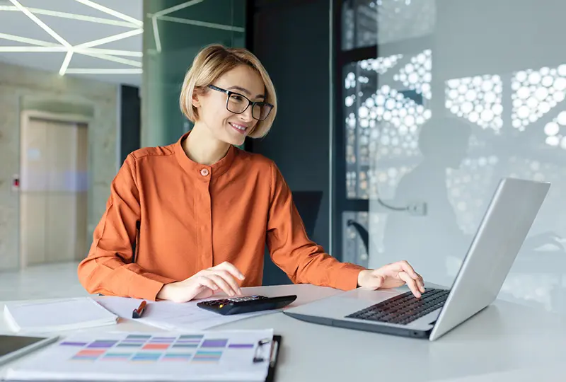 Woman working on laptop in modern office.