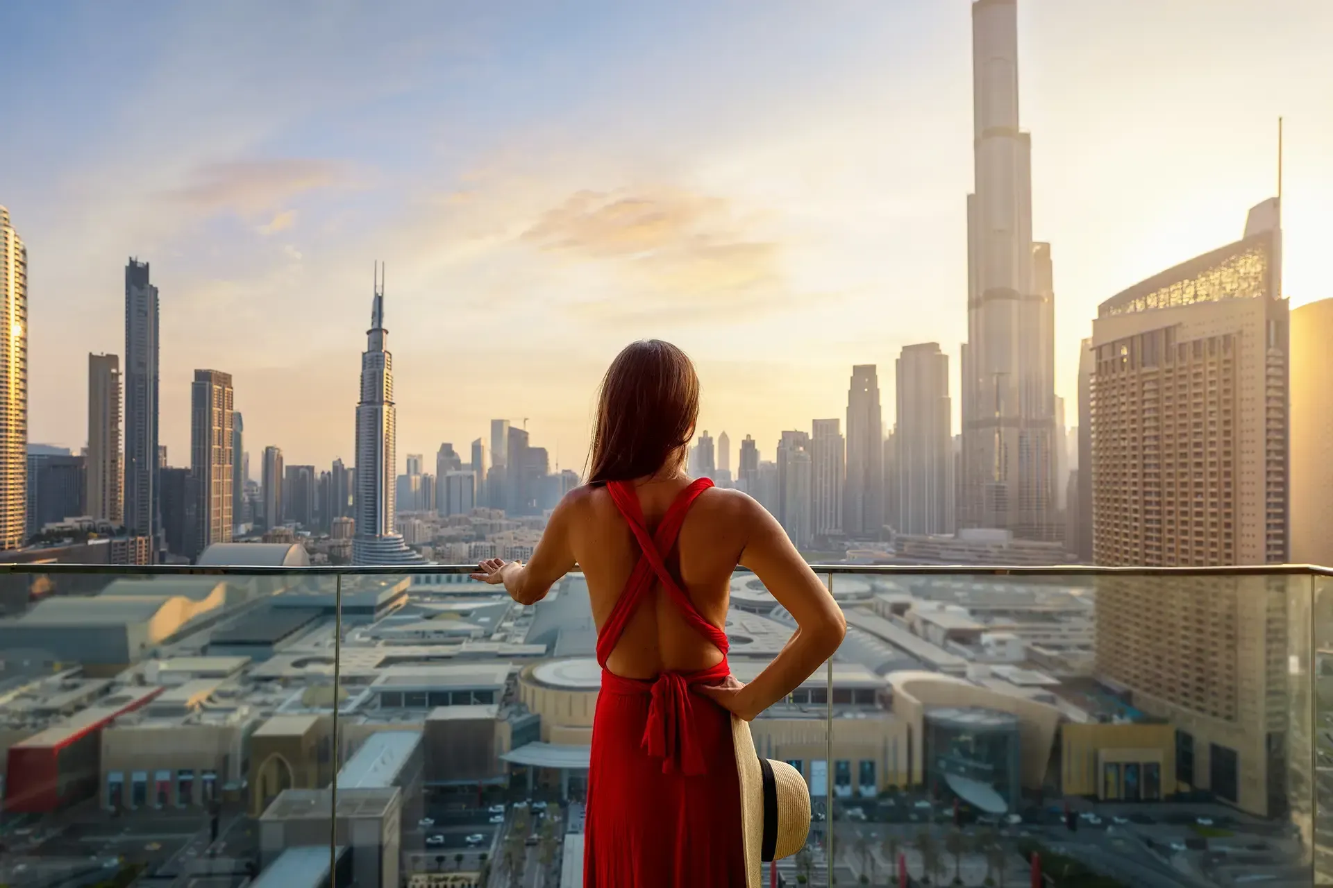 Woman overlooking city skyline at sunset.