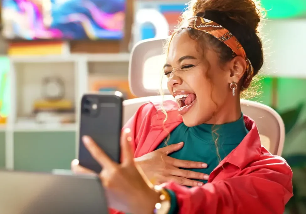 Woman taking a joyful selfie with smartphone.