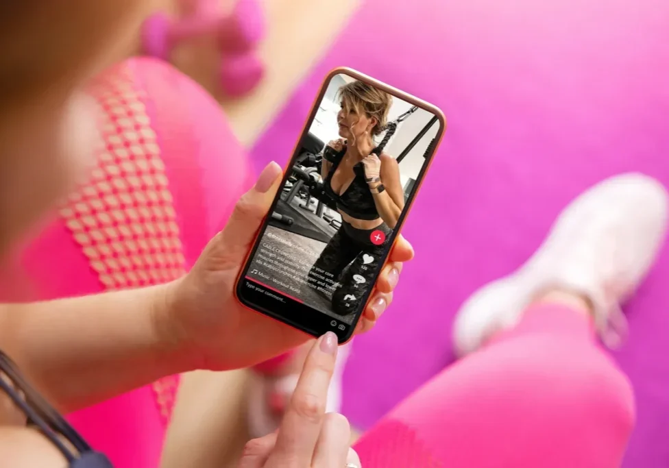 Person watching fitness video on smartphone.