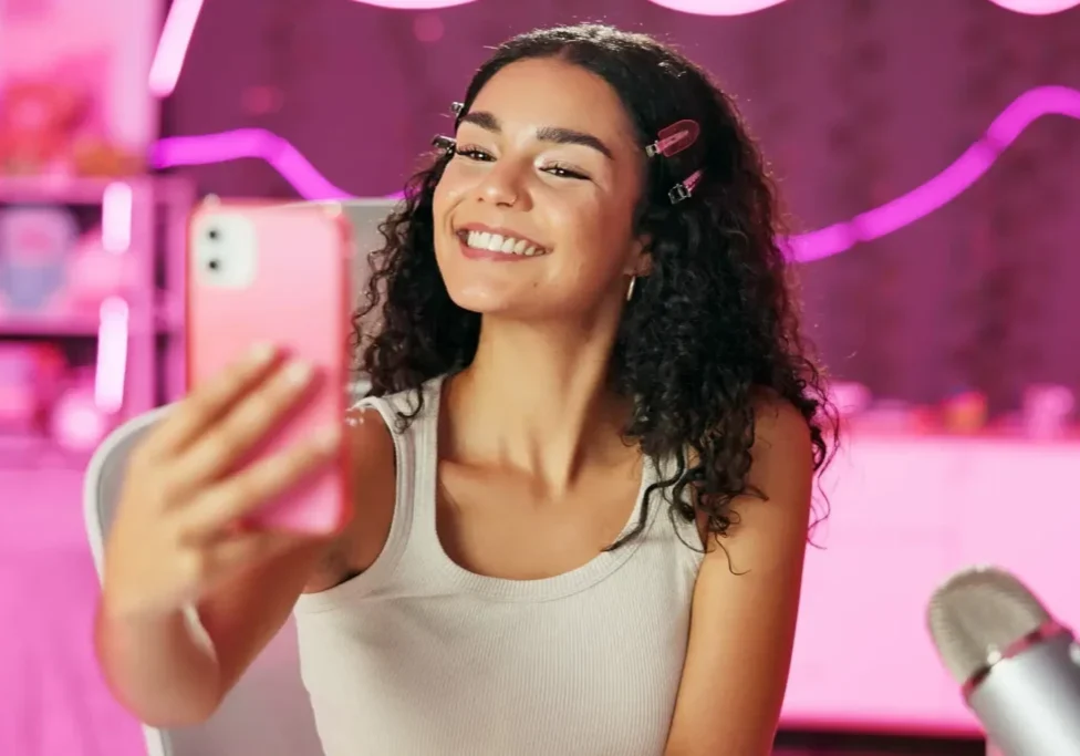 Woman taking a selfie in pink room.