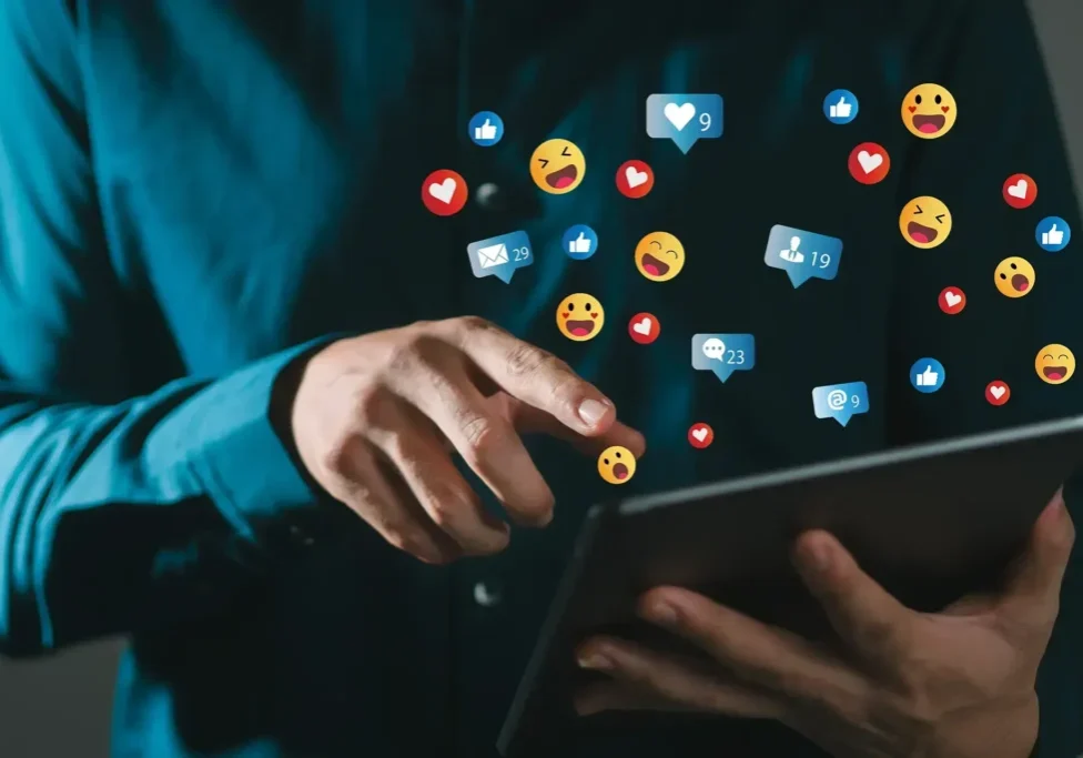 Person interacting with social media icons on tablet.